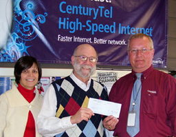 Mike Repinski (right) of CenturyLink renews the company's commitment to literacy with a donation to Literacy Partners' Mary Gotstein and Bob Garfinkel